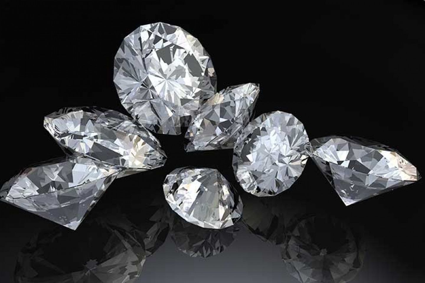 A group of diamonds are sitting on top of each other on a black surface.