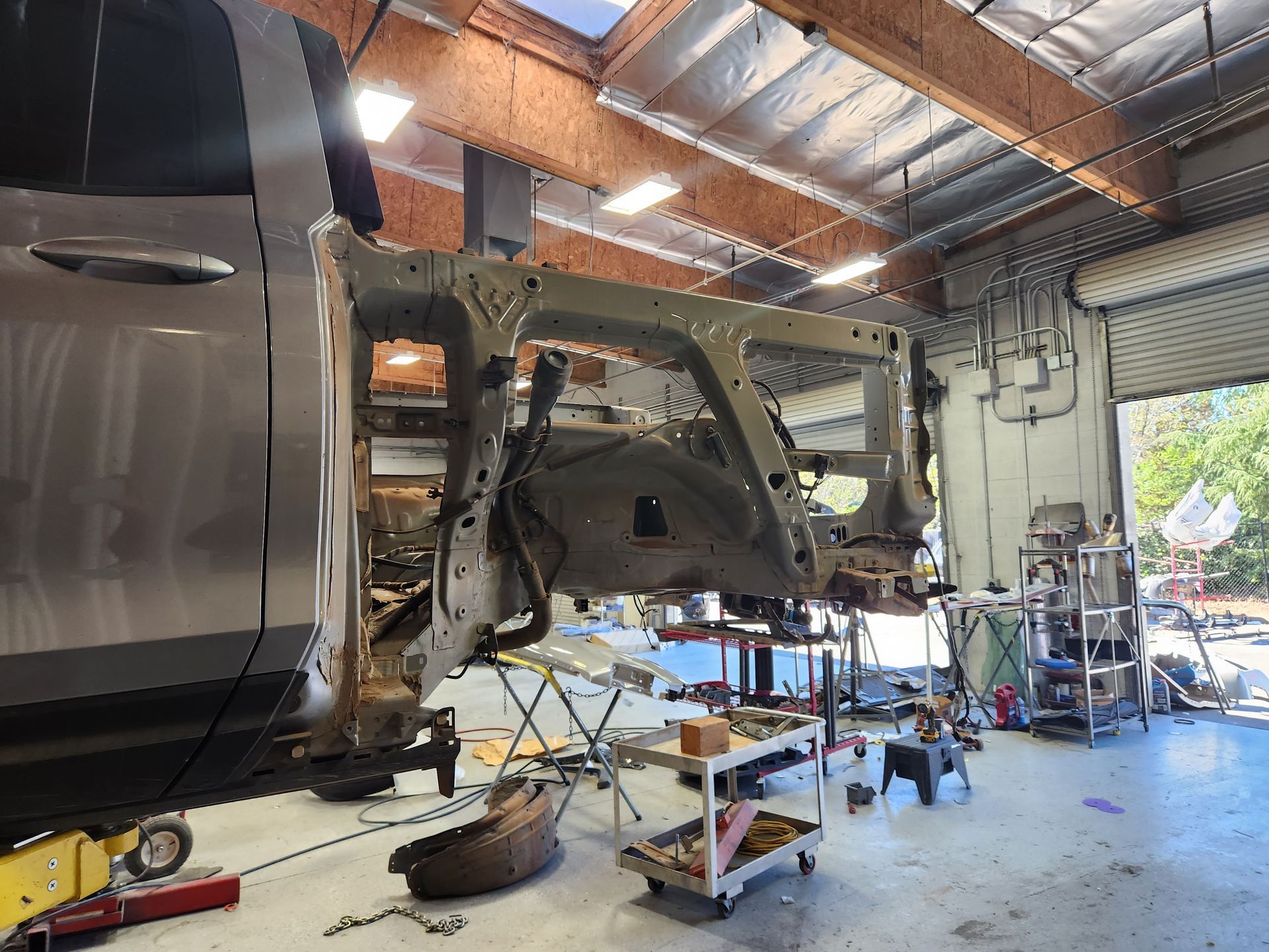 Truck cab removed in a repair shop, with the exposed frame and tools around it. | Tripp's Auto Body