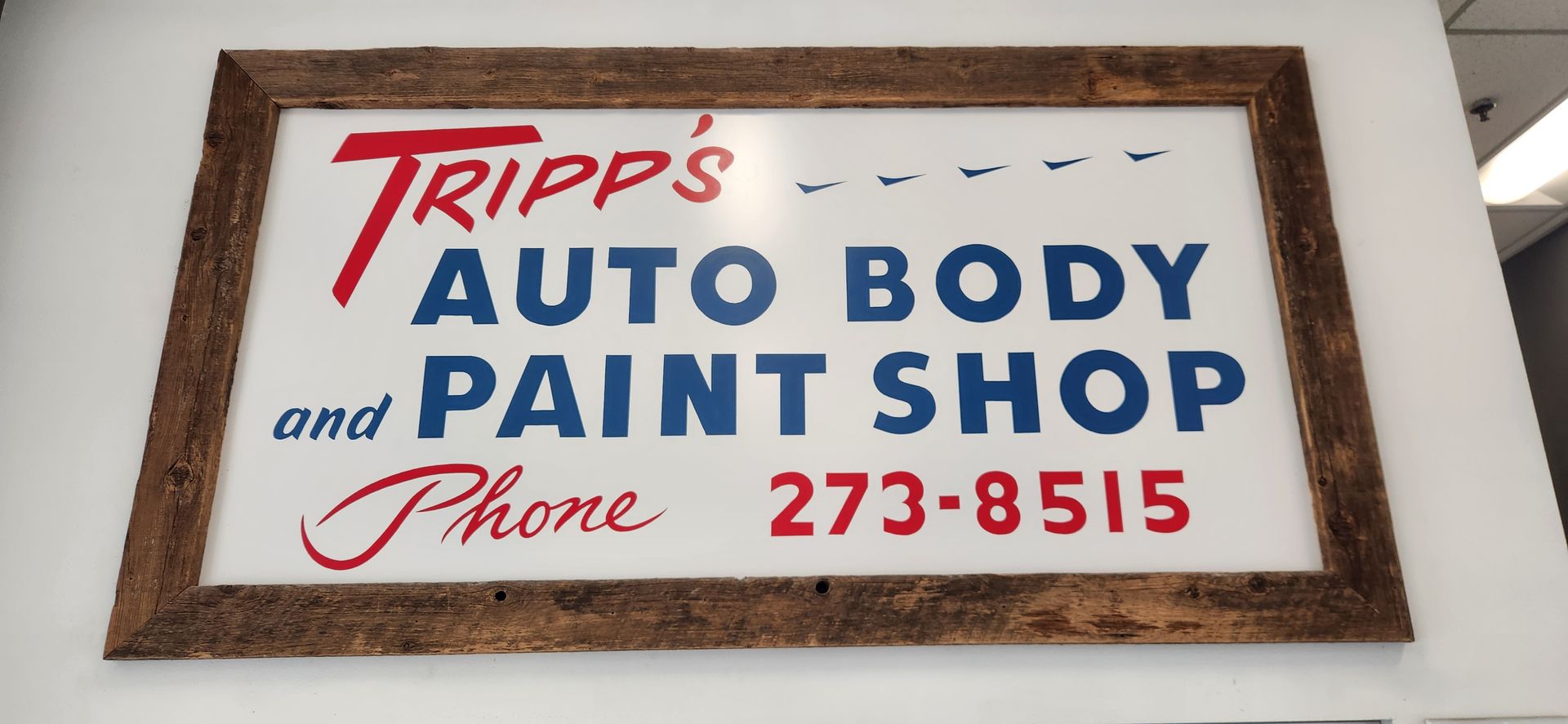 Tripp’s Auto Body and Paint Shop sign with phone number 273-8515 in red and blue text | Tripp's Auto Body