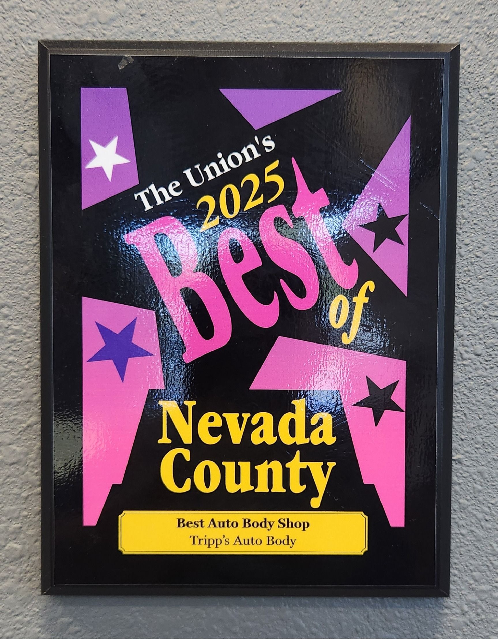 Framed award poster reading “The Union’s 2025 Best of Nevada County” in pink, purple, yellow, and black. | Tripp's Auto Body