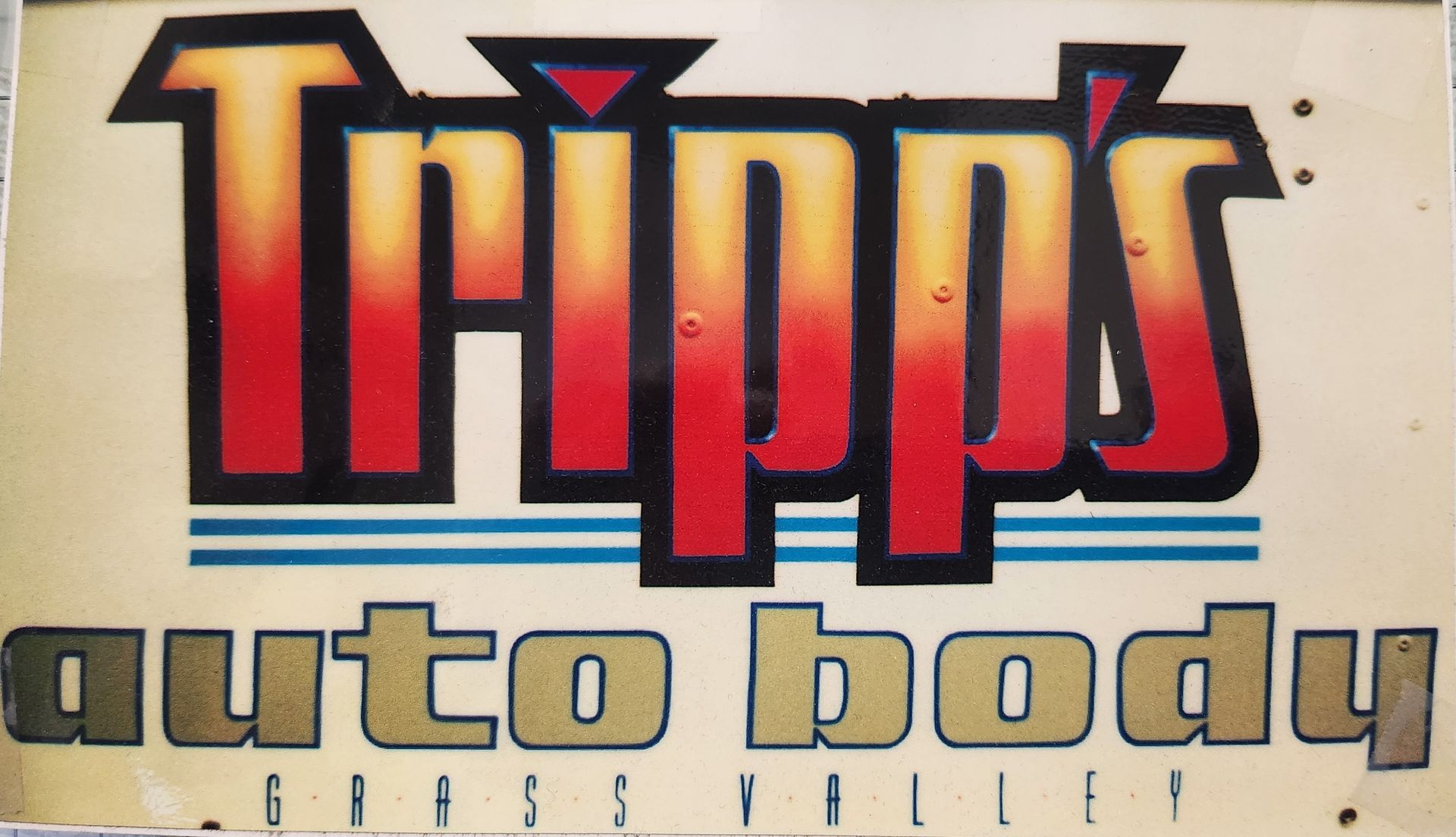 Tripps Auto Body logo with bold red and black lettering on a light background | Tripp's Auto Body