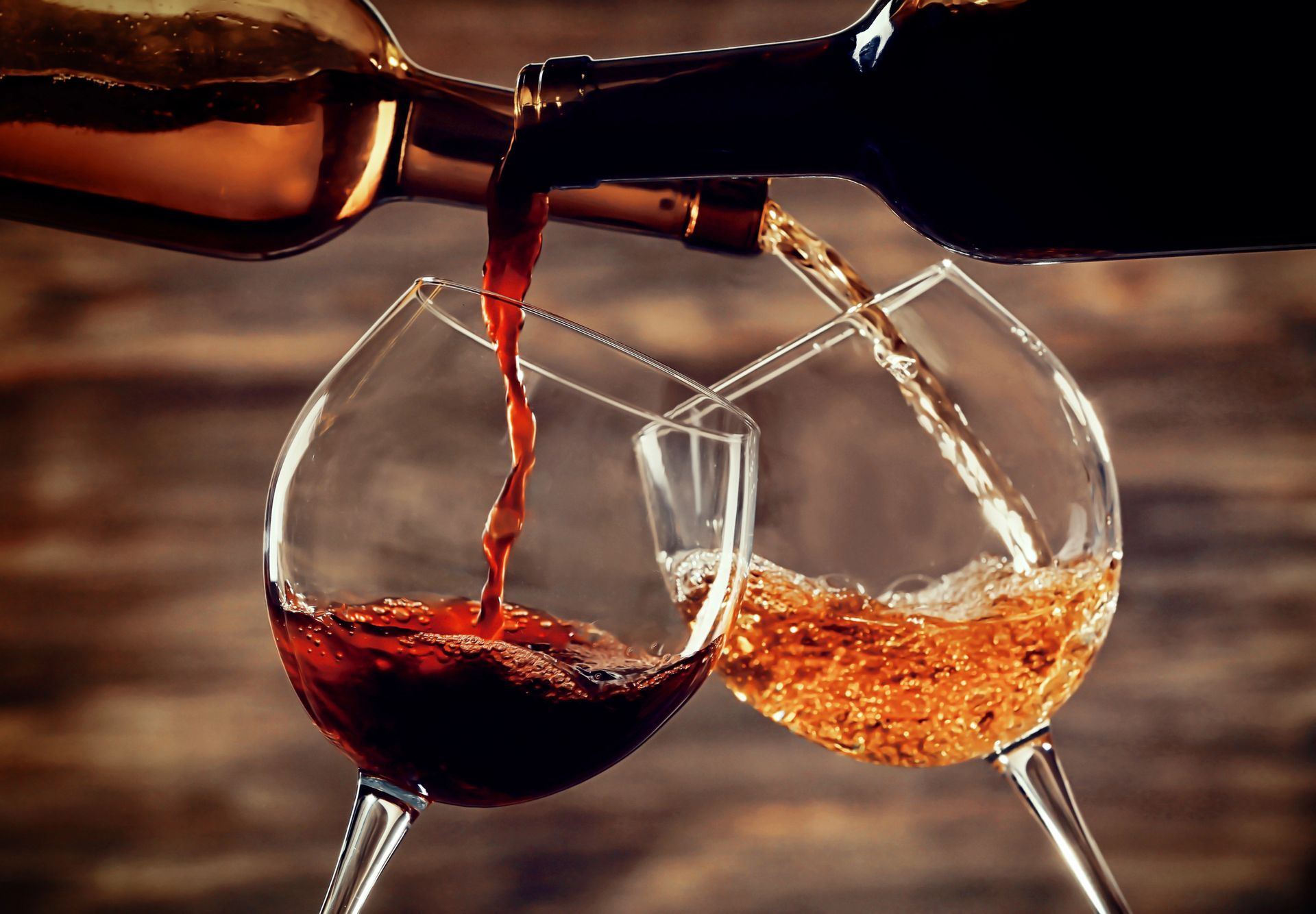 Il vino viene versato in due calici con stelo, uno contenente vino rosso e l'altro vino bianco.