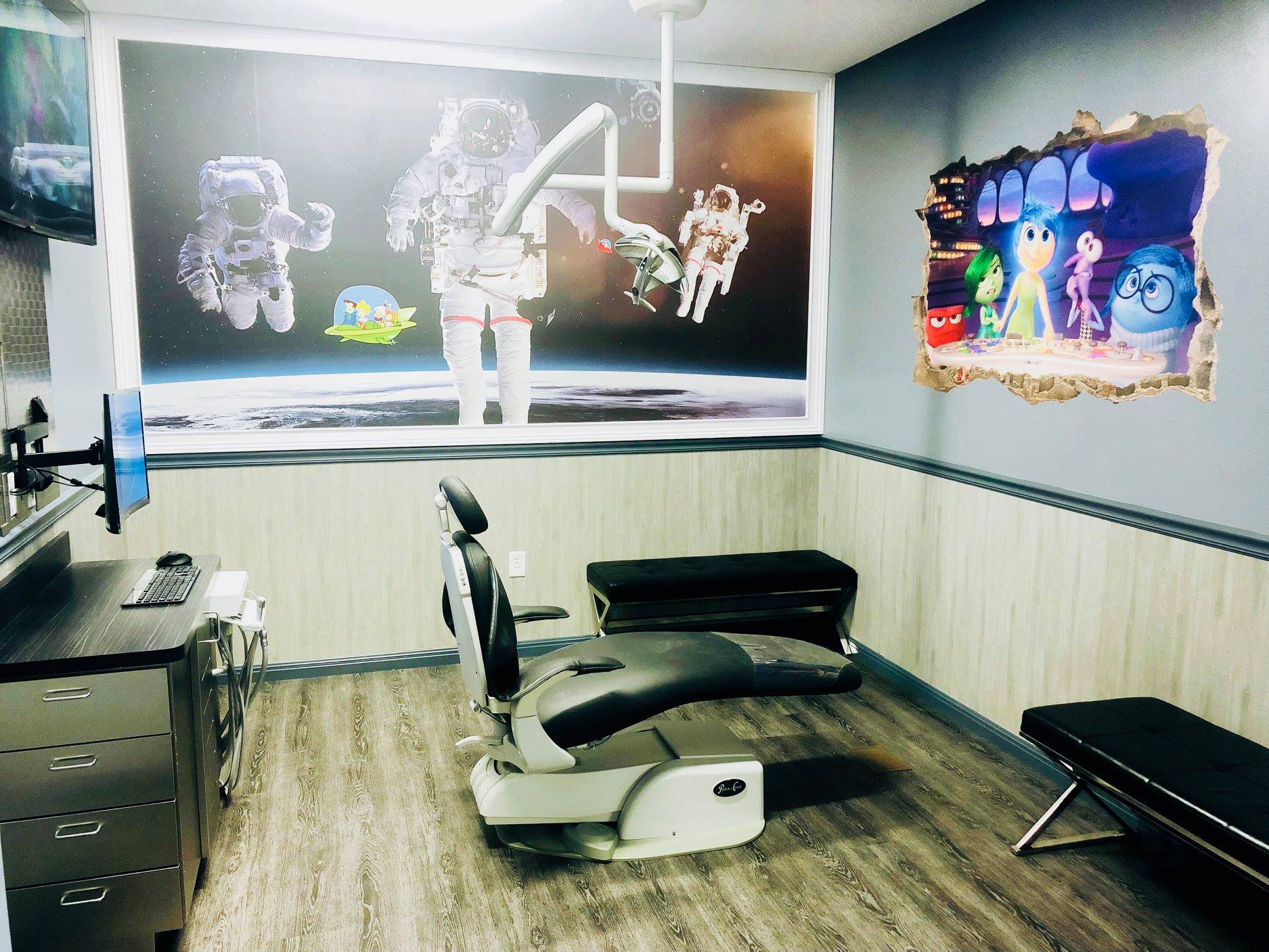 Barber shop interior with a haircut chair, black wall art, and a bench along the right wall.