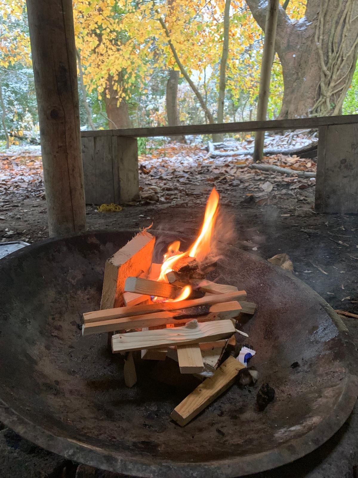 A fire is being lit in a large metal bowl.