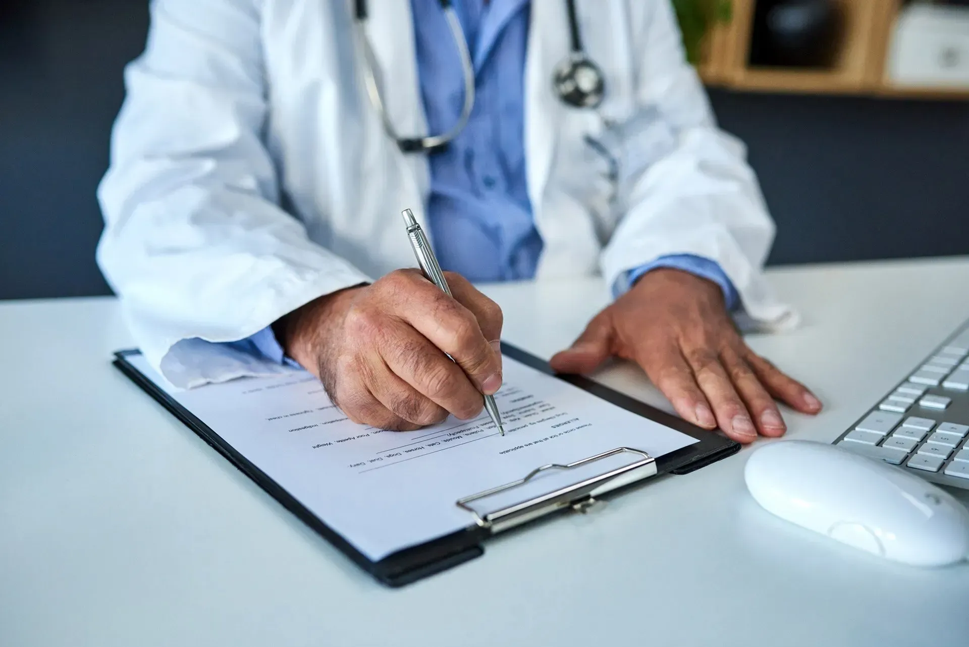 A doctor is writing on a clipboard with a pen. A doctor is writing on a clipboard with a pen.
