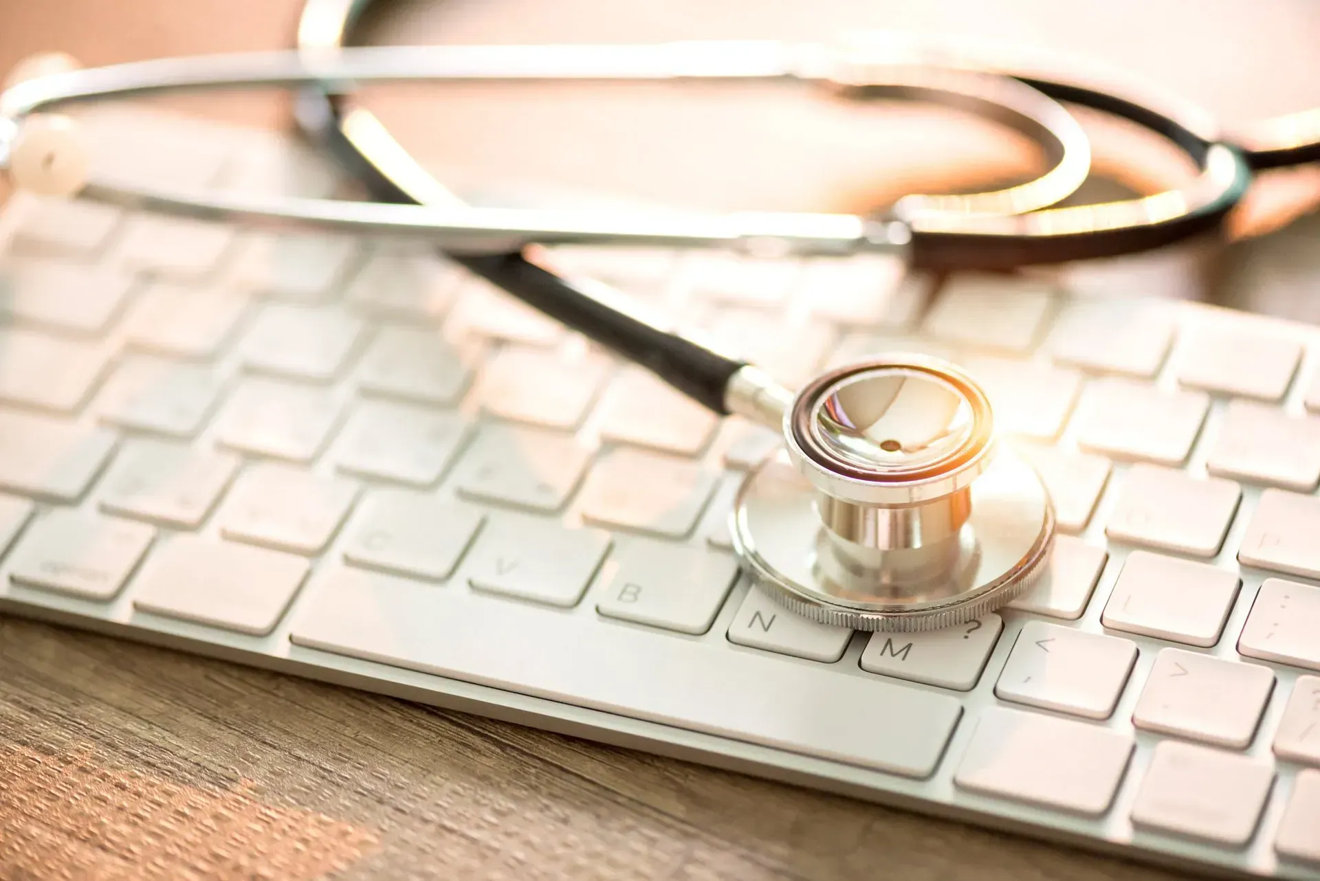A stethoscope is sitting on top of a computer keyboard. A stethoscope is sitting on top of a computer keyboard.