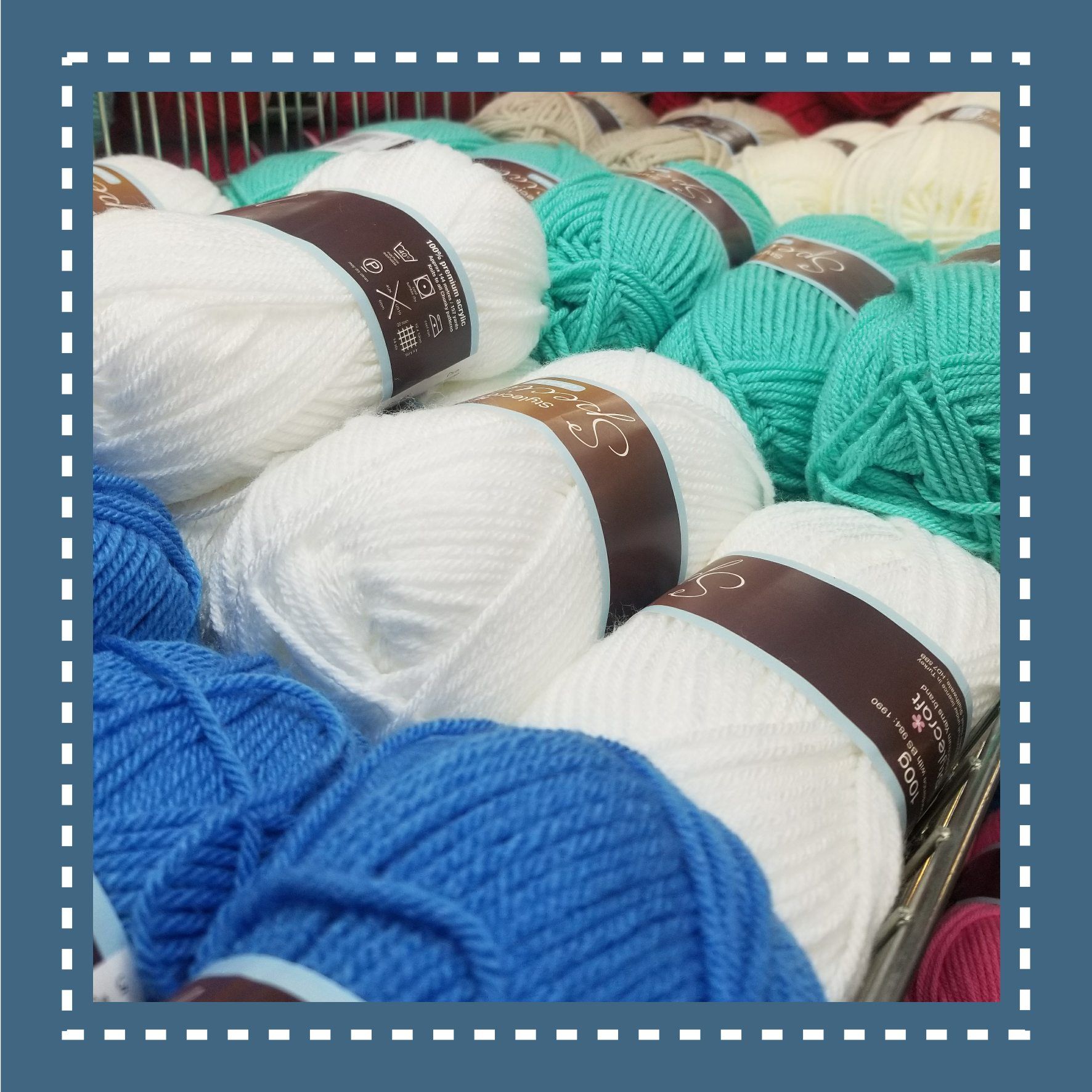 Balls of white, teal, and blue yarn are displayed in a shop.