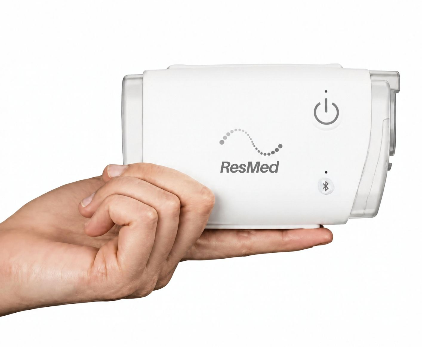 Mano sosteniendo un dispositivo ResMed blanco con un símbolo de encendido.
