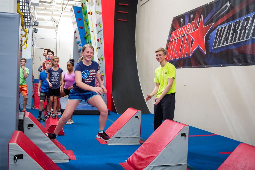 A girl having fun doing Ninja Warrior Course