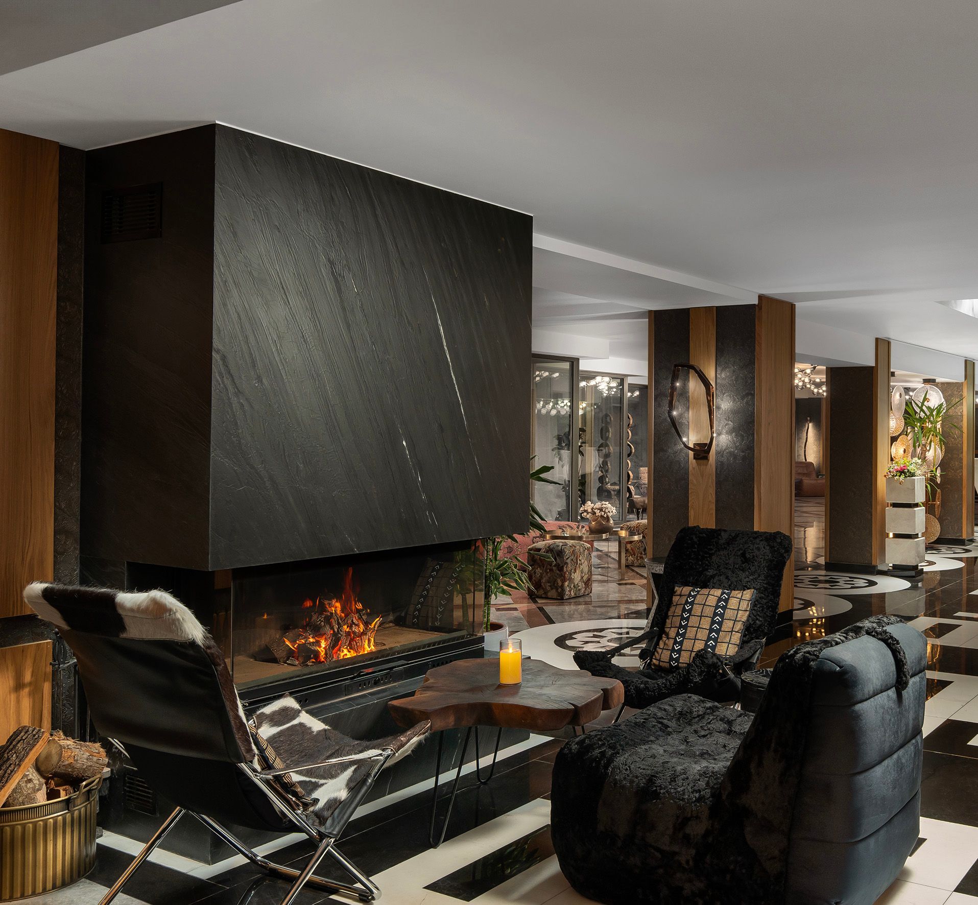 Modern lounge with a sleek black fireplace, leather chairs, and warm ambient lighting