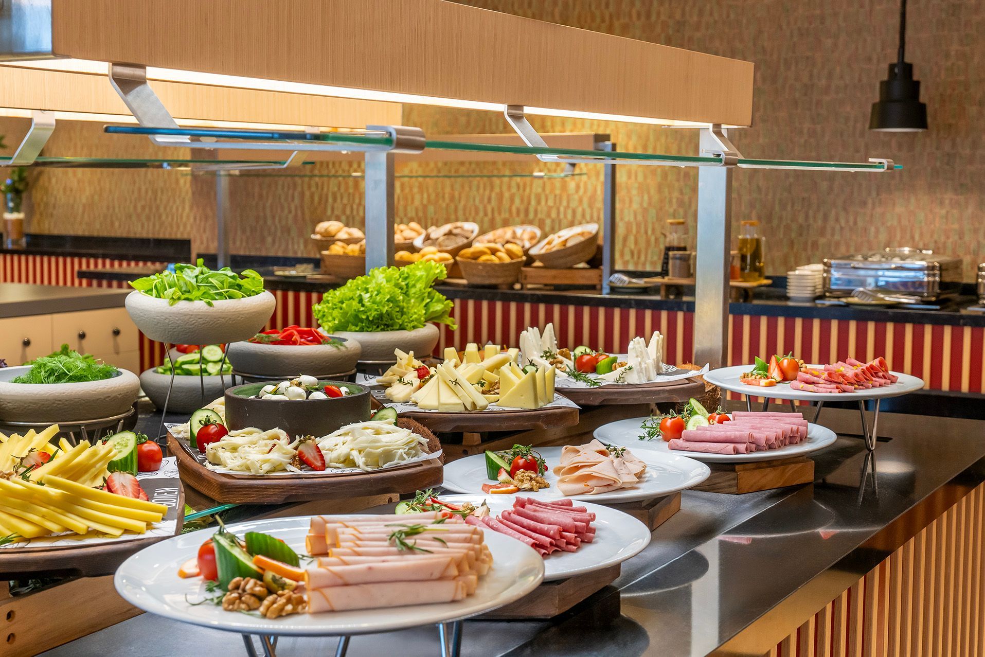 Buffet of assorted salads, breads, and appetizers on a restaurant counter
