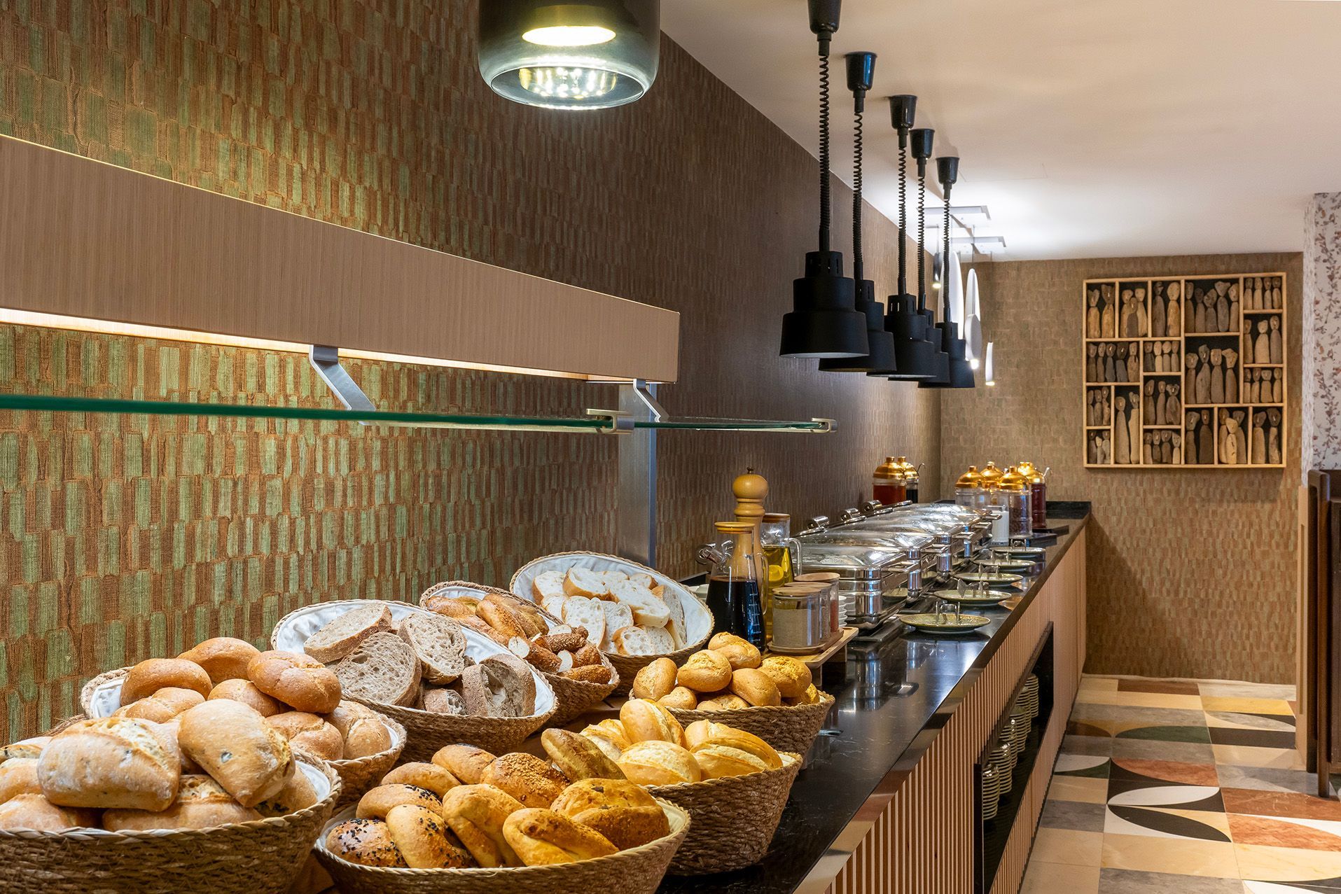 Bakery display with baskets of assorted breads along a long counter in a warm, modern interior