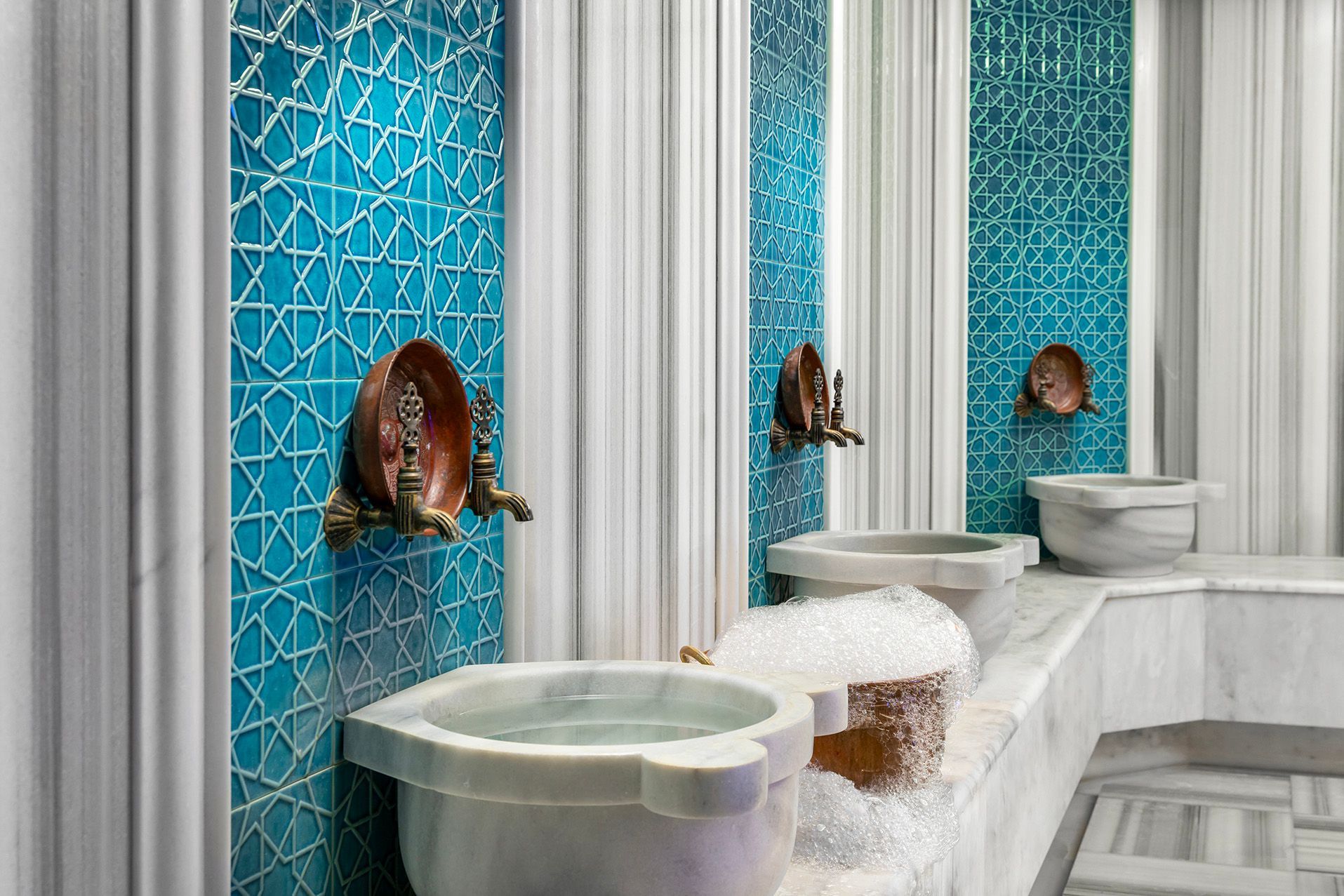 Modern bathroom sinks with turquoise mosaic wall panels and copper bowl basins
