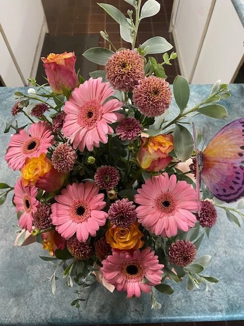A Bouquet of Pink and Yellow Flowers With a Butterfly in the Background — Wingham Nursery and Florist PTY Ltd In Wingham, NSW