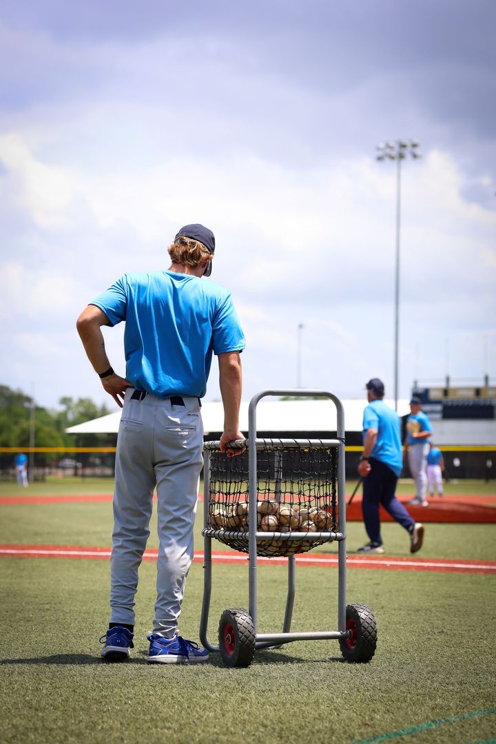 Baseball player sliding into home plate, kicking up dirt.