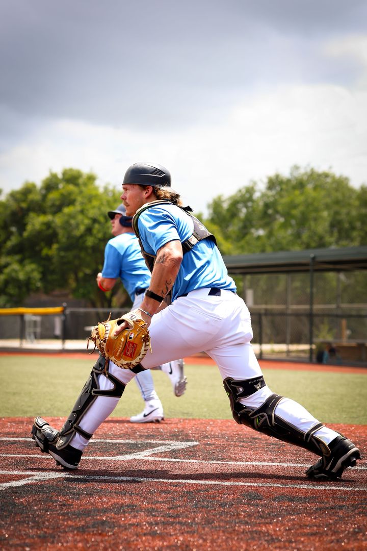 Baseball player catches a ball; final score: Cowboys 8, Timberhogs 9. Blue and gold color scheme.