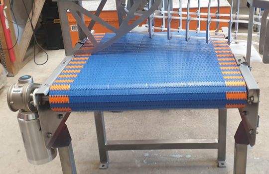 A conveyor belt is sitting on top of a metal table.
