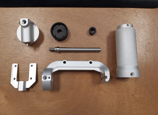 A bunch of metal parts on a wooden table
