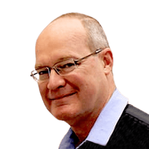 A bald man wearing glasses and a blue shirt is smiling.