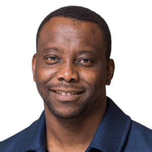 A man wearing a blue shirt is smiling for the camera