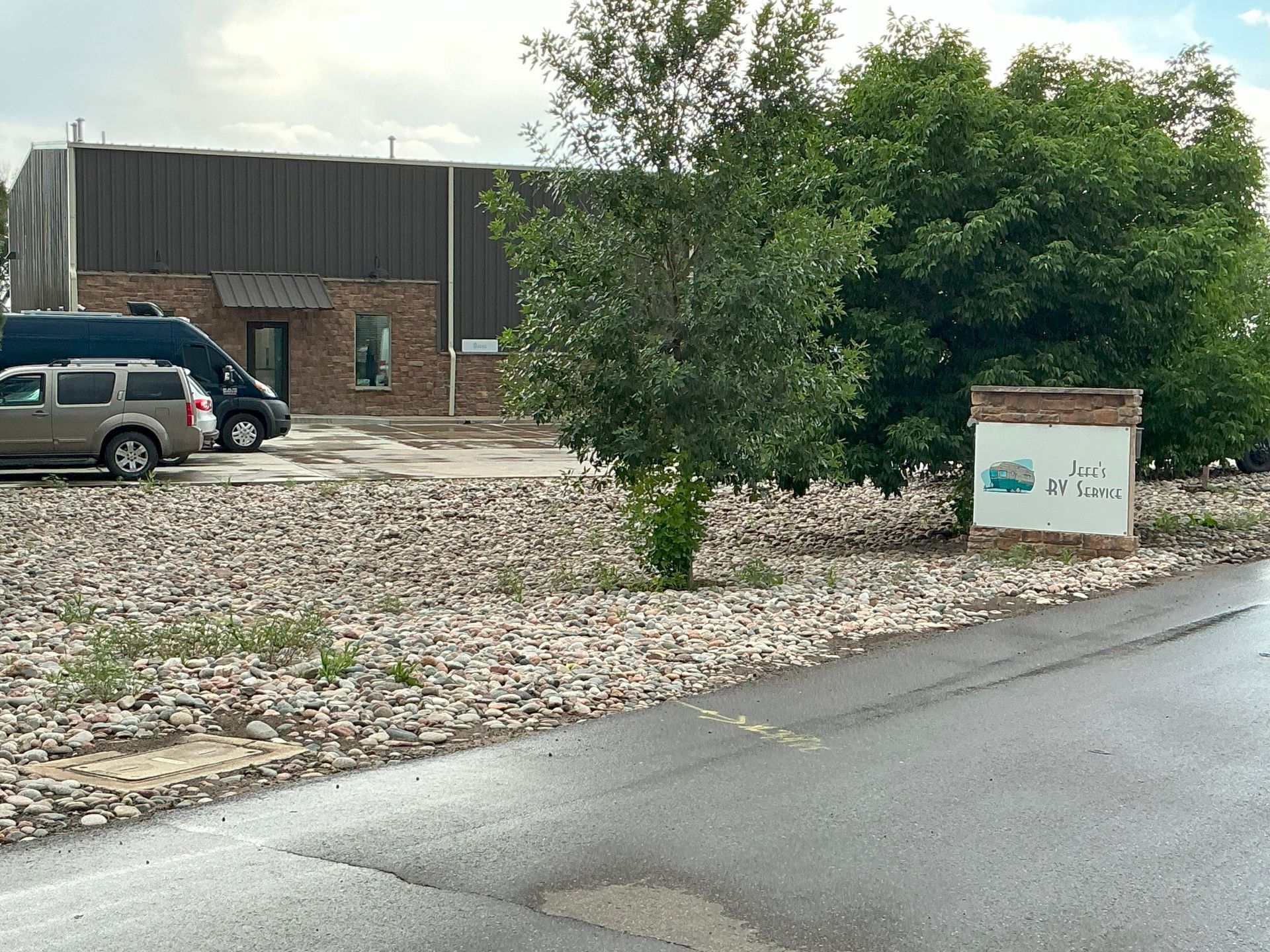 View of a street and building with a gravel lot. A sign for 