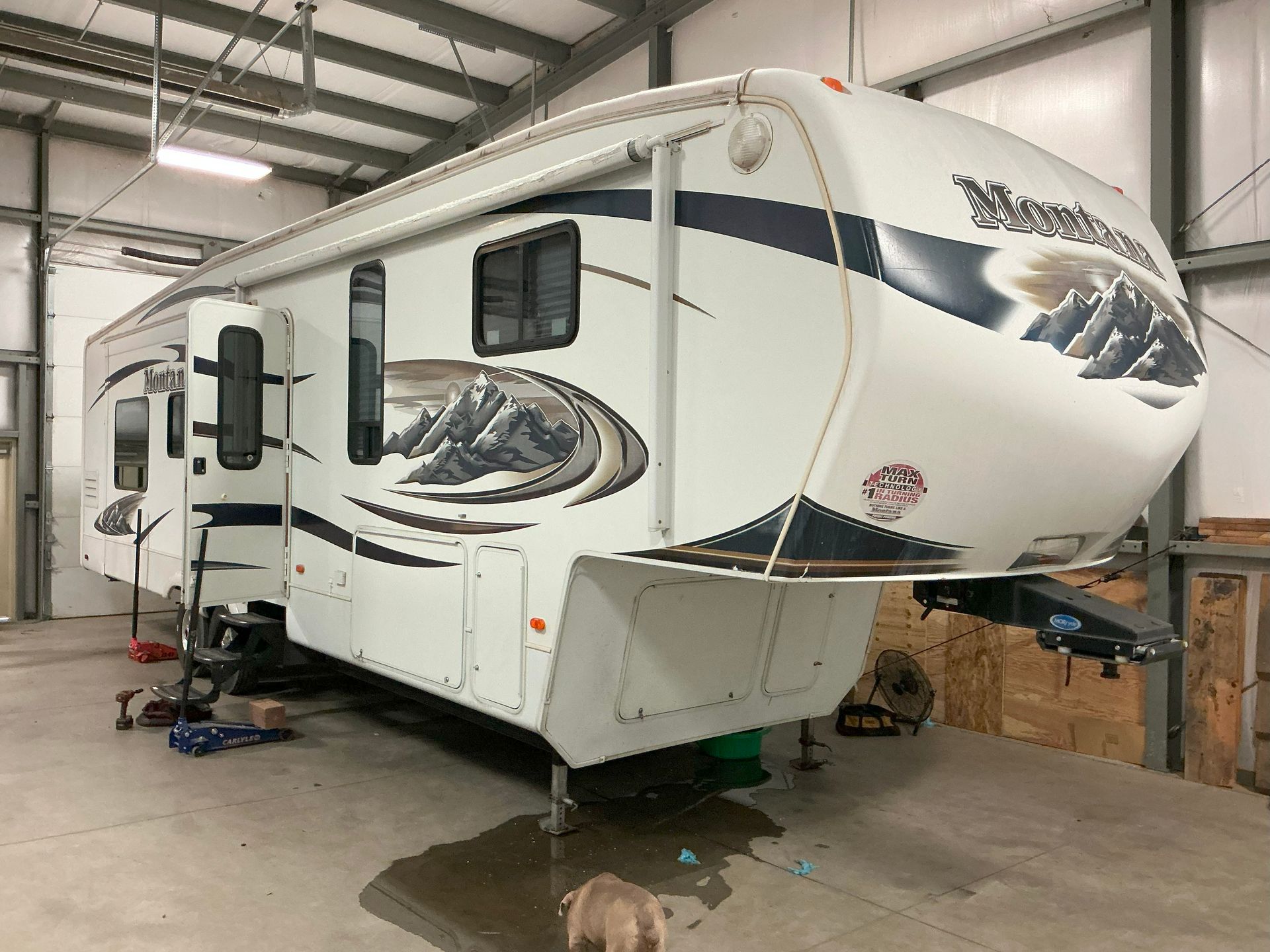 White Montana fifth-wheel RV in a garage with slides extended.