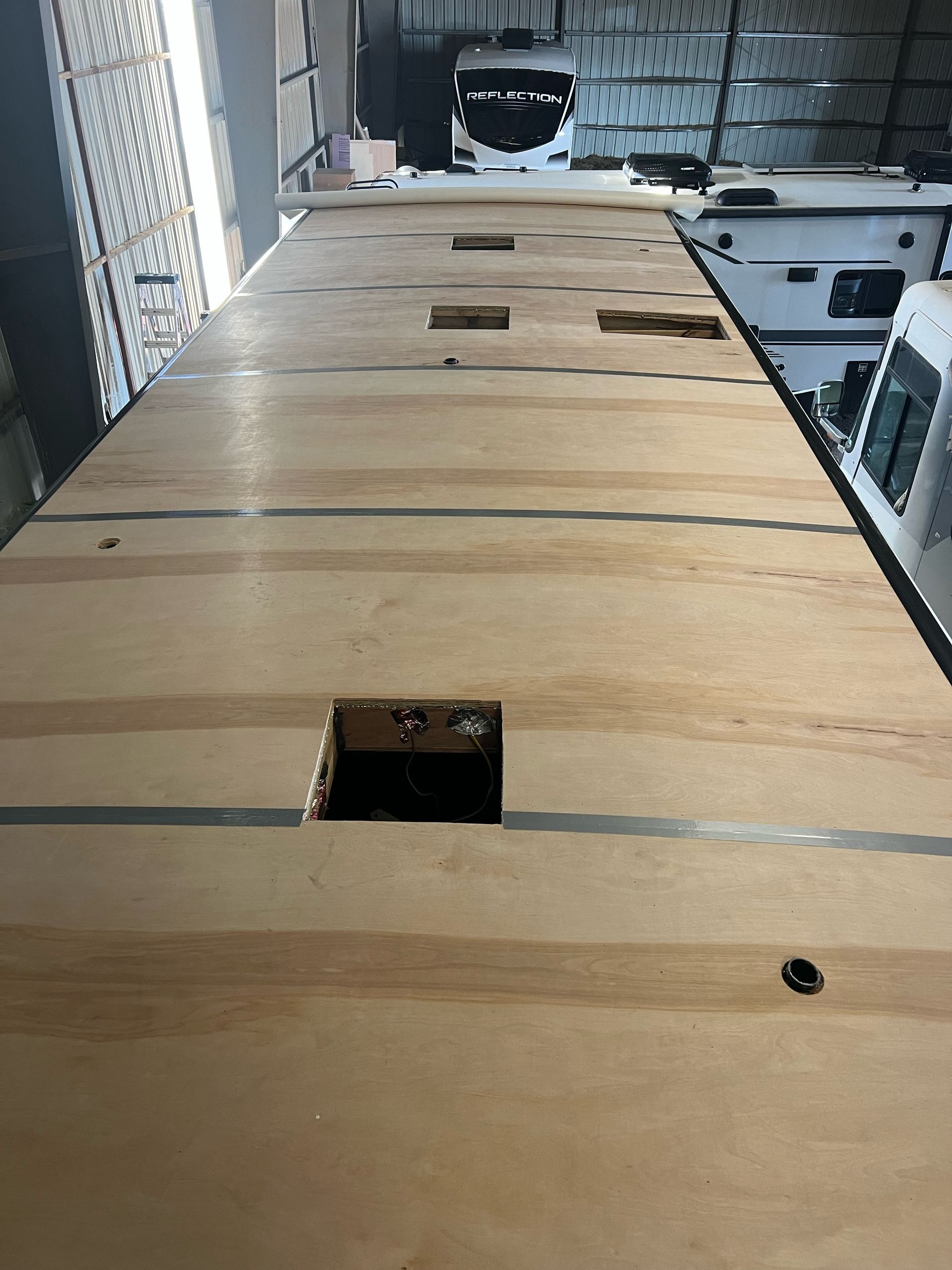 Wooden flatbed with several square and rectangular openings, possibly for equipment.