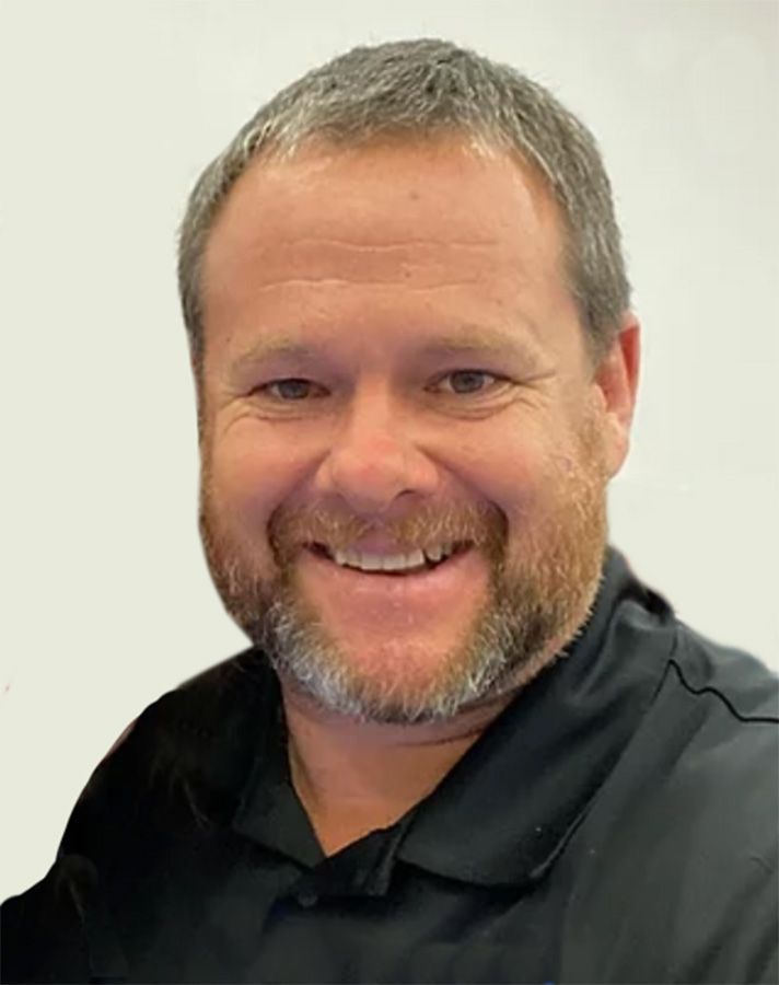 Smiling man in a black shirt against a light background