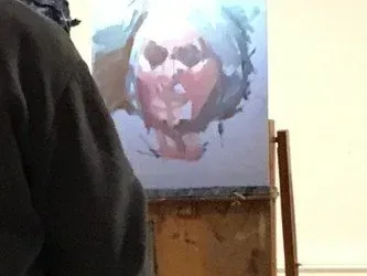 Abstract painting of a face on a canvas, with a dark figure partially blocking the left side.