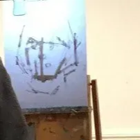 A sketch of a face on a white canvas in a studio setting