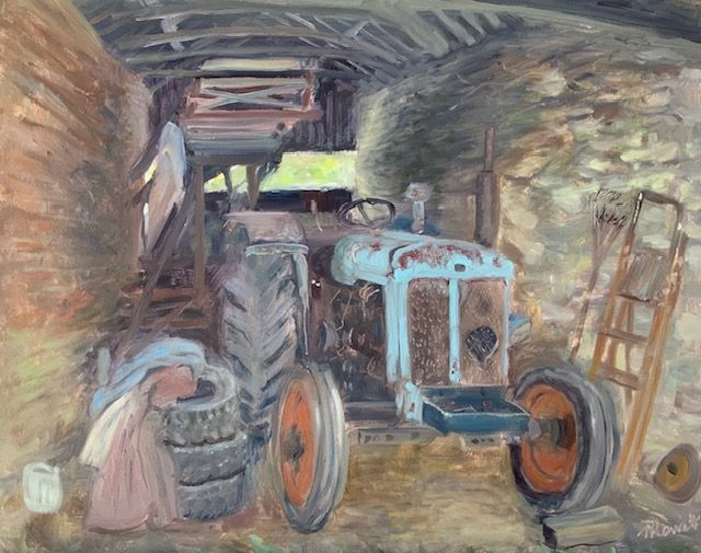 Old blue tractor parked in a dim barn, with barrels and wooden ladders nearby.