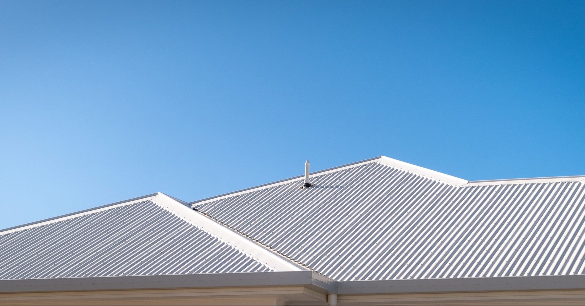 Blue sky above a gray corrugated metal roof with a small rooftop vent. — Dunnerite Plumbing in Mount Peter, QLD