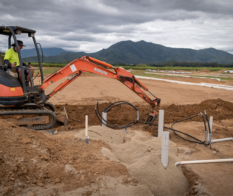 An Orange Excavator Works at a Construction Site With Pipes — Dunnerite Plumbing in Mount Peter, QLD