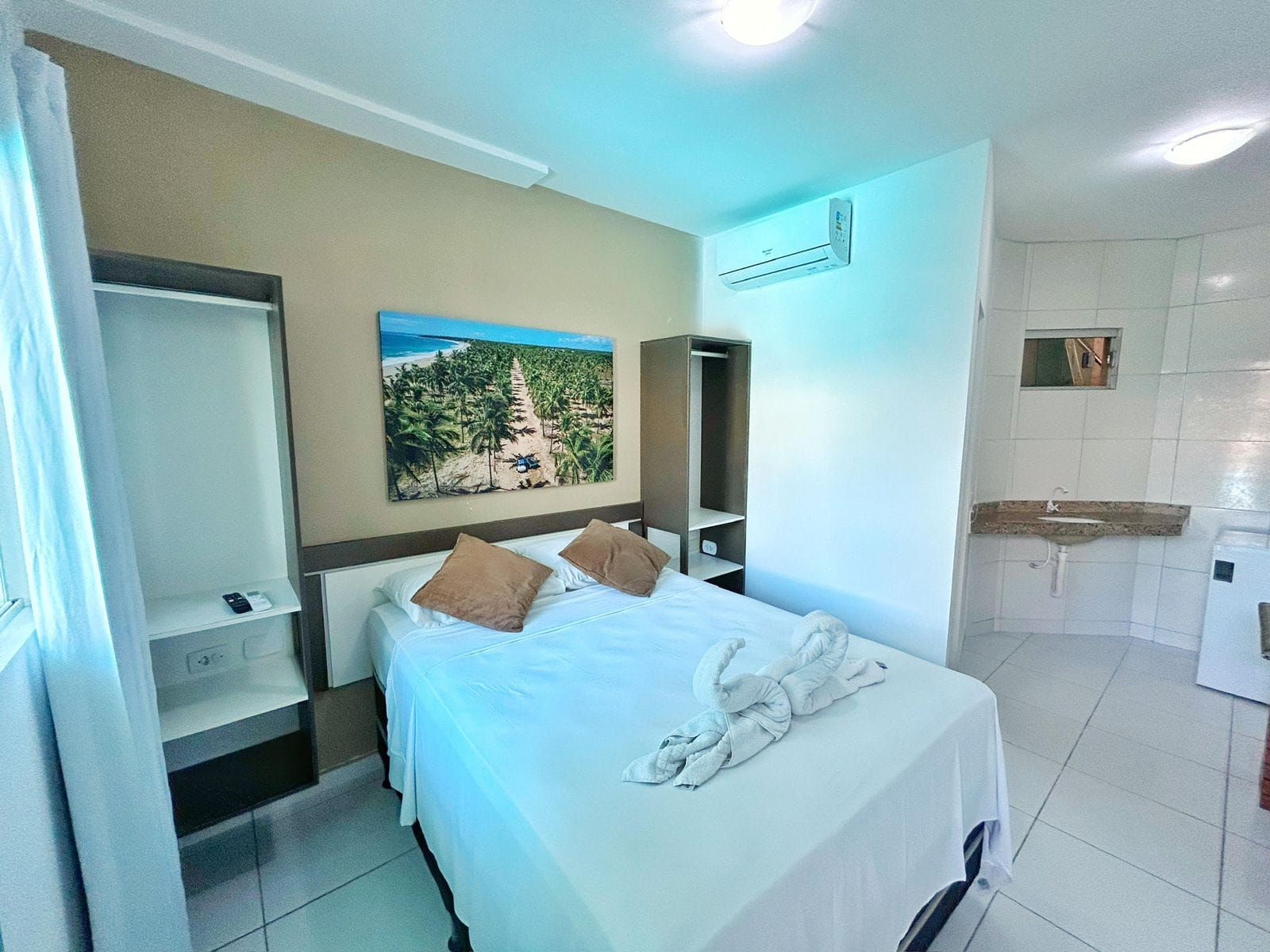 Um quarto com uma cama e um quadro na parede.