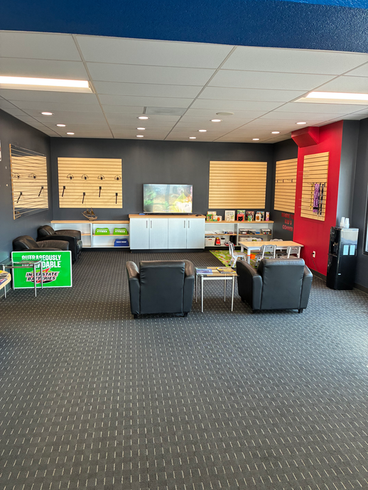 Modern office lobby with lounge chairs, carpeted floor, wall art, and red accent wall