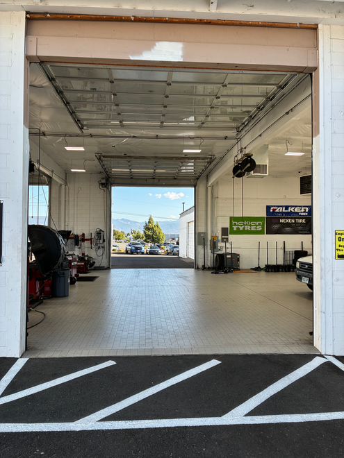 Open garage bay with cars inside, leading to a bright outdoor view. Open garage bay with cars inside, leading to a bright outdoor view.