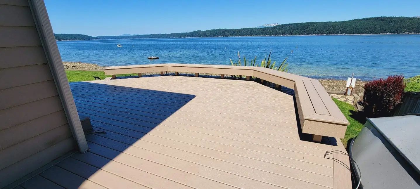 Wooden deck with built-in bench overlooking a blue lake on a sunny day