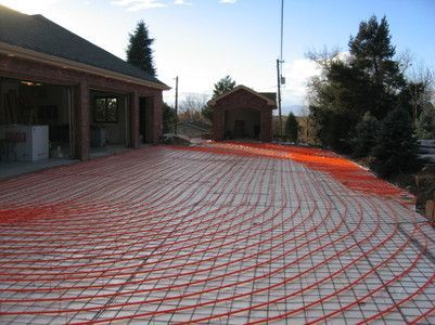 PEX tubing for a radiant snow-melt system laid out in a grid pattern on a driveway before pouring concrete.