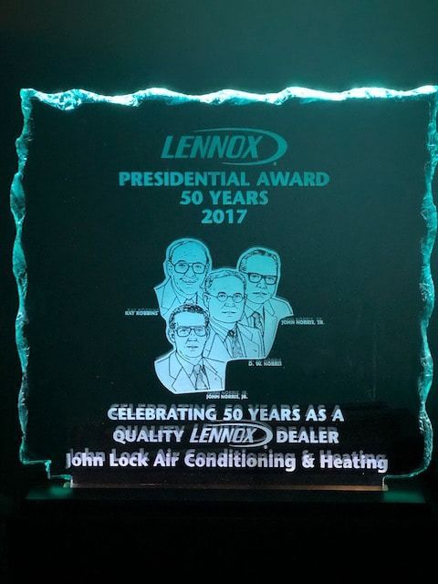 A blue-lit, glass Lennox Presidential Award plaque for 50 years of service, presented to John Lock Air Conditioning.
