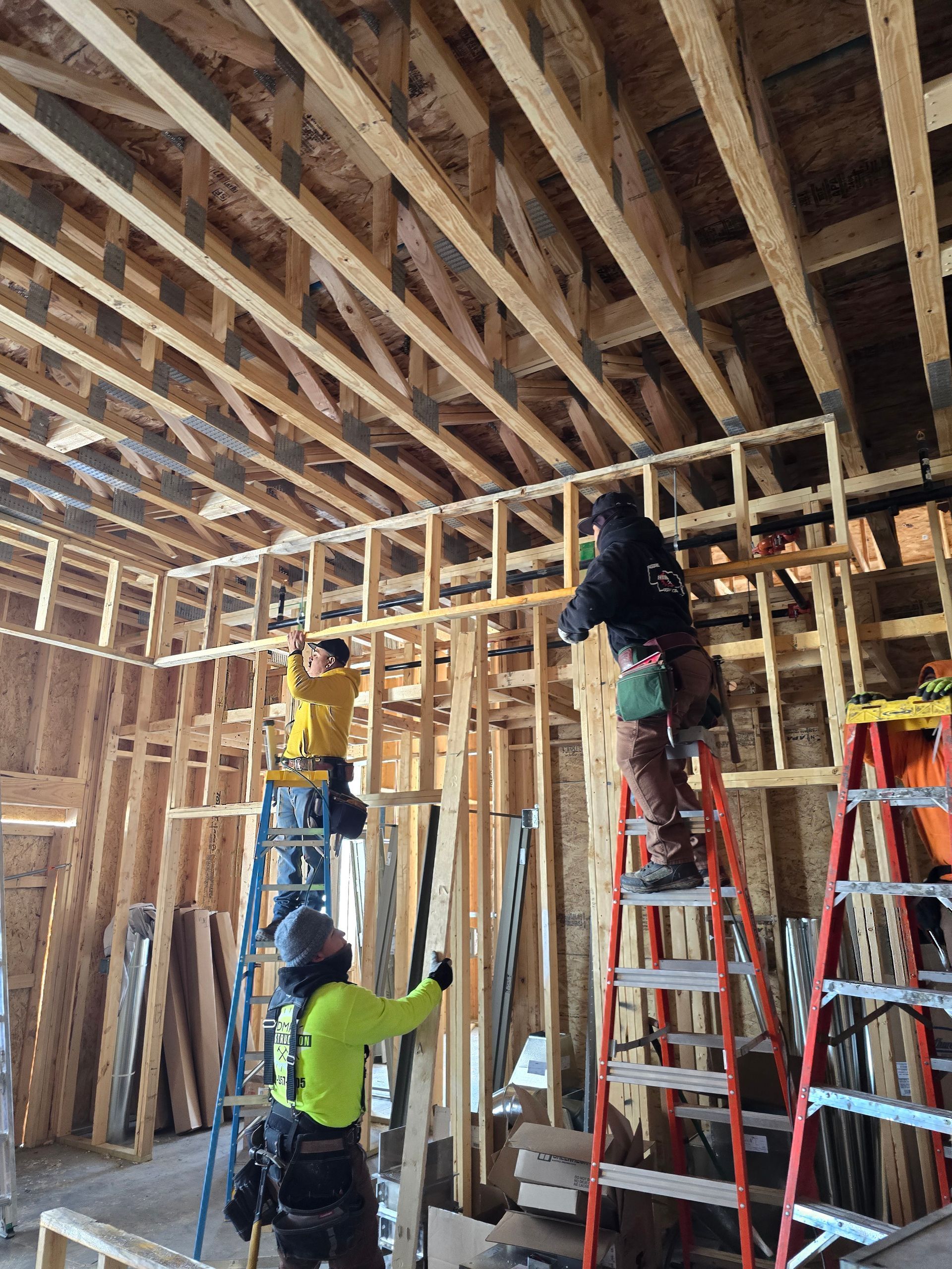 Construction workers framing interior walls of a building.