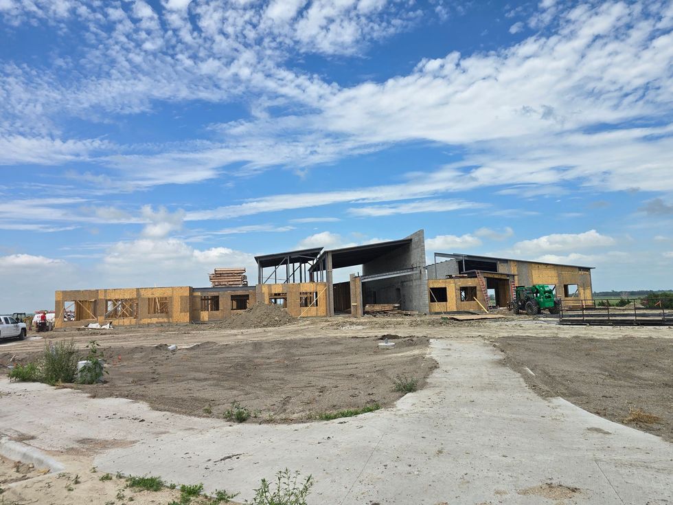 Construction site with a partially built building under a blue sky.