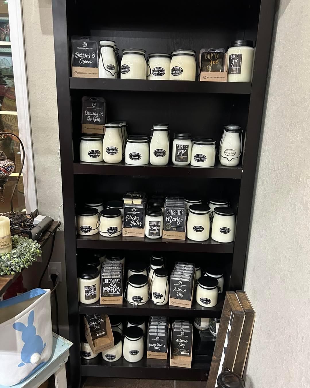 A shelf filled with lots of jars and candles.