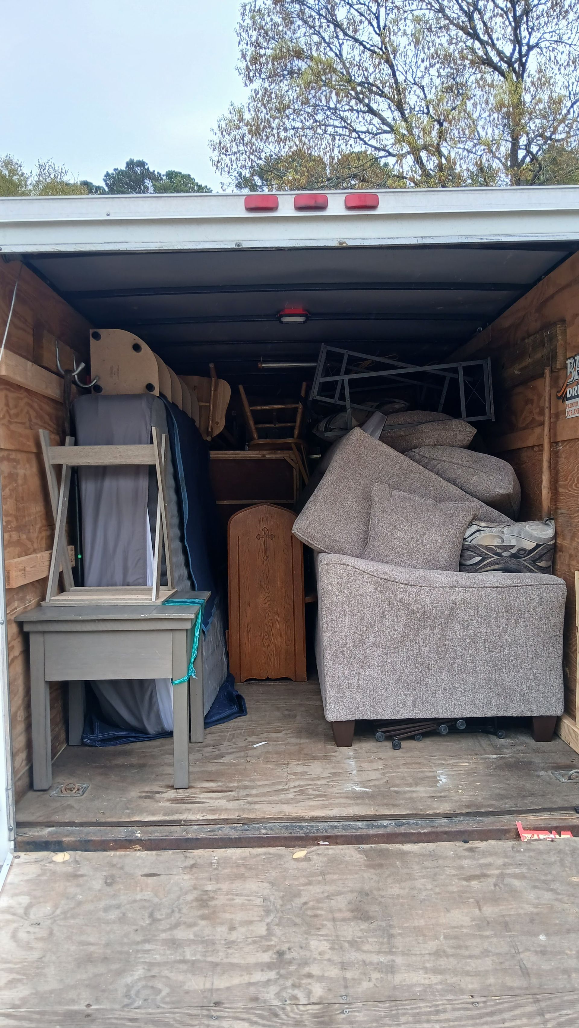 Packed moving truck loaded with furniture, boxes, and appliances inside the cargo bay