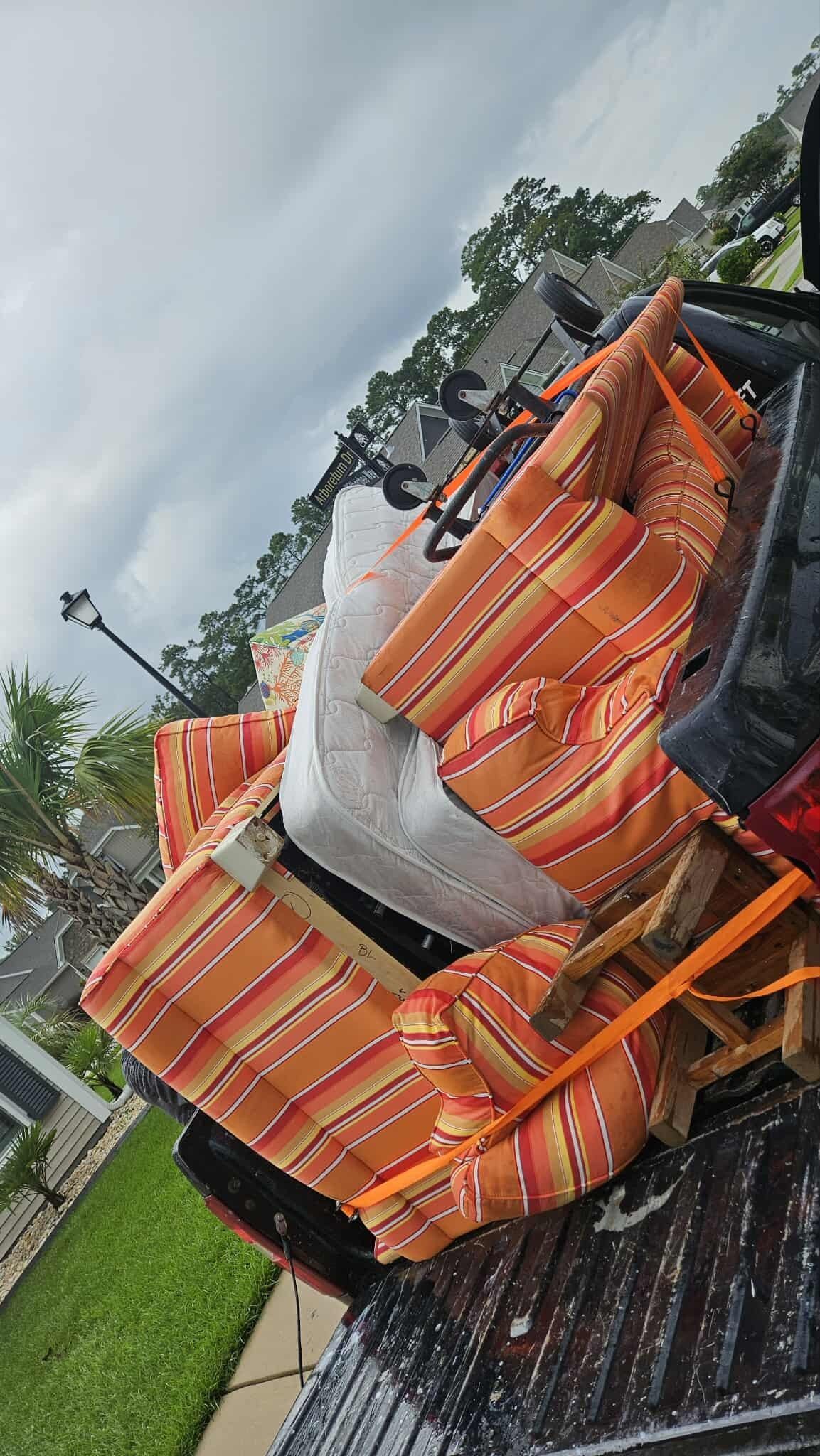 Overturned orange vehicle on a wet road with debris and trees nearby
