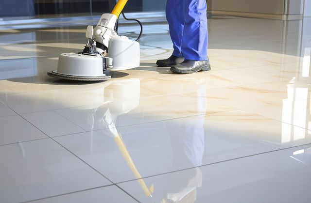 Floor polisher cleaning a glossy tiled floor in a bright indoor space