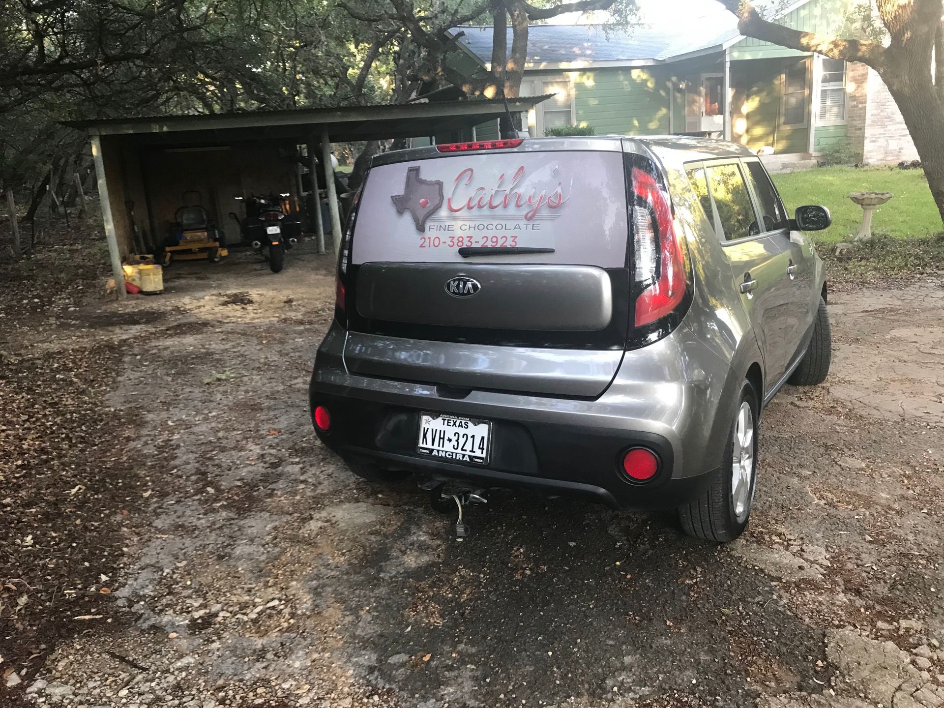 A car with a texas license plate is parked in a driveway.