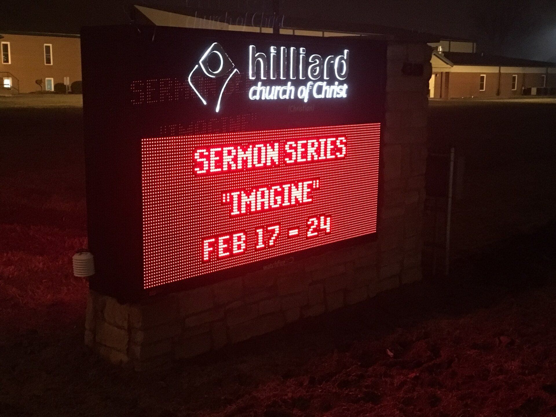 Church sign glowing red at night with “Sermon Series Imagine Feb 17–24” and Hillcrest Church logo.