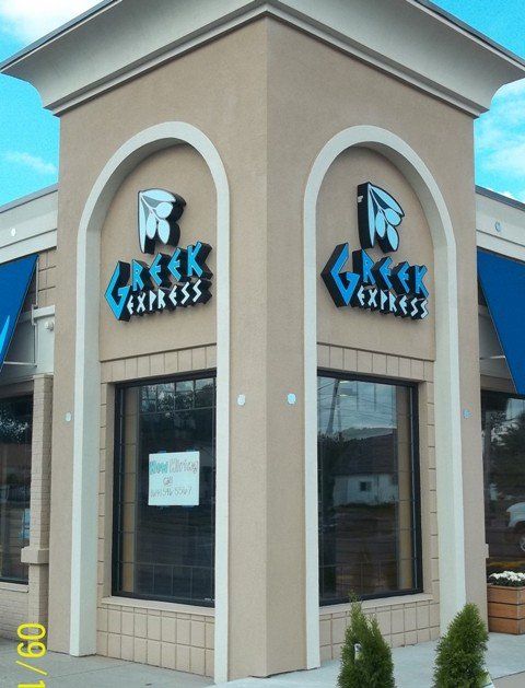 Brick storefront with two arched windows and blue Creek Express signs on the facade