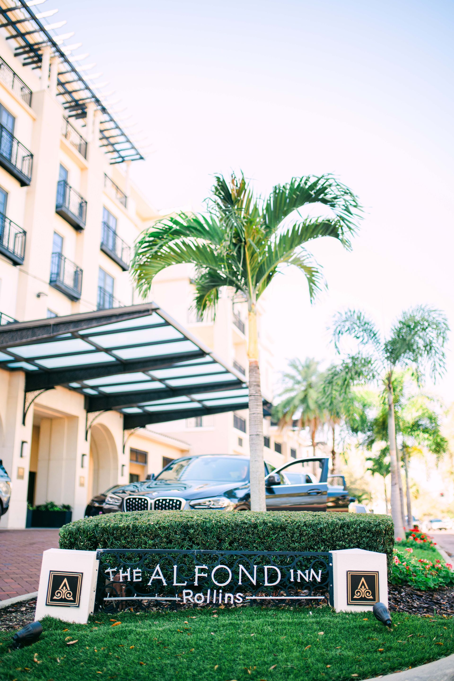 Sign for The Alfond Inn, Rollins College; car at entrance.