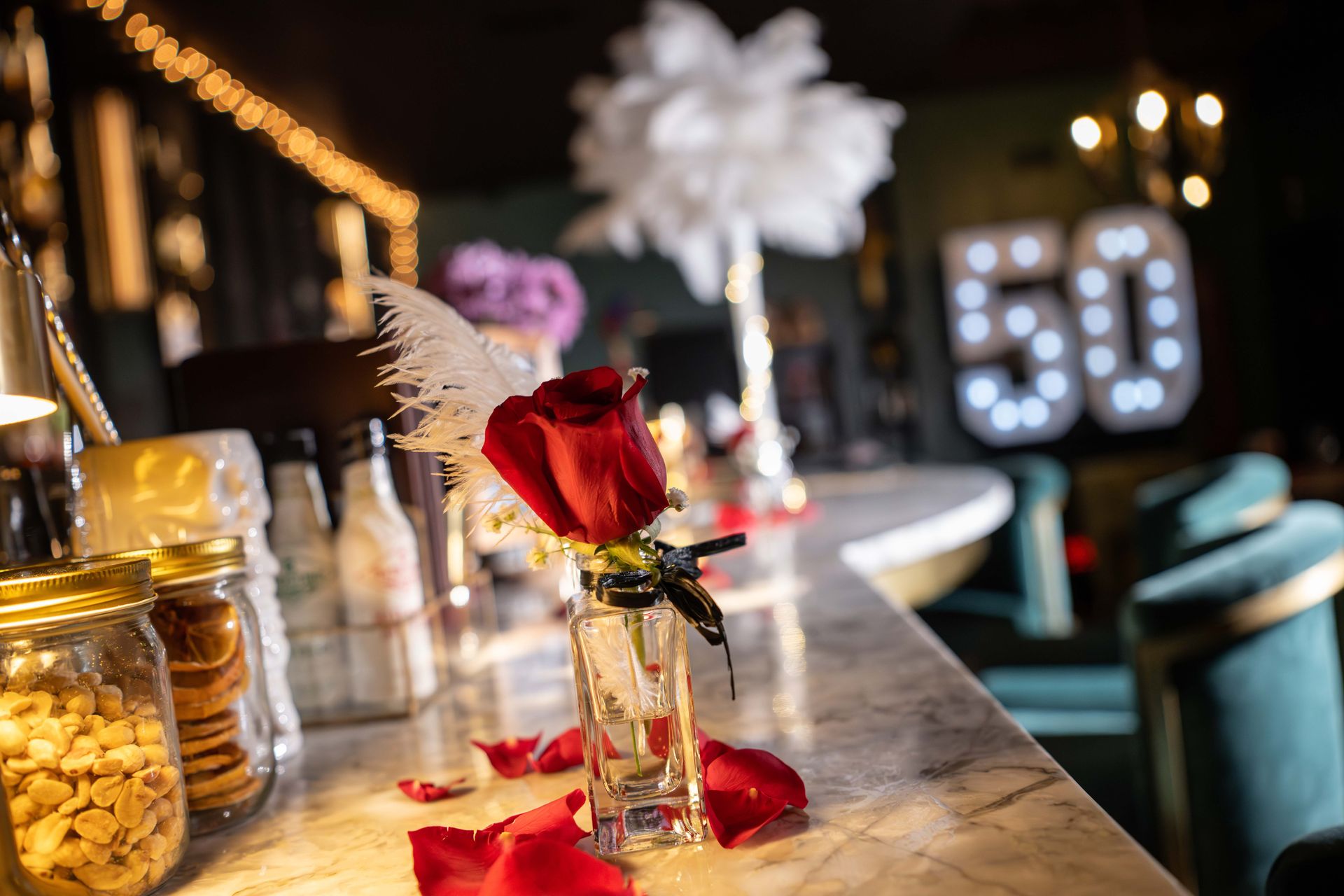 Red rose in a small vase on a marble bar; party decor; a large 